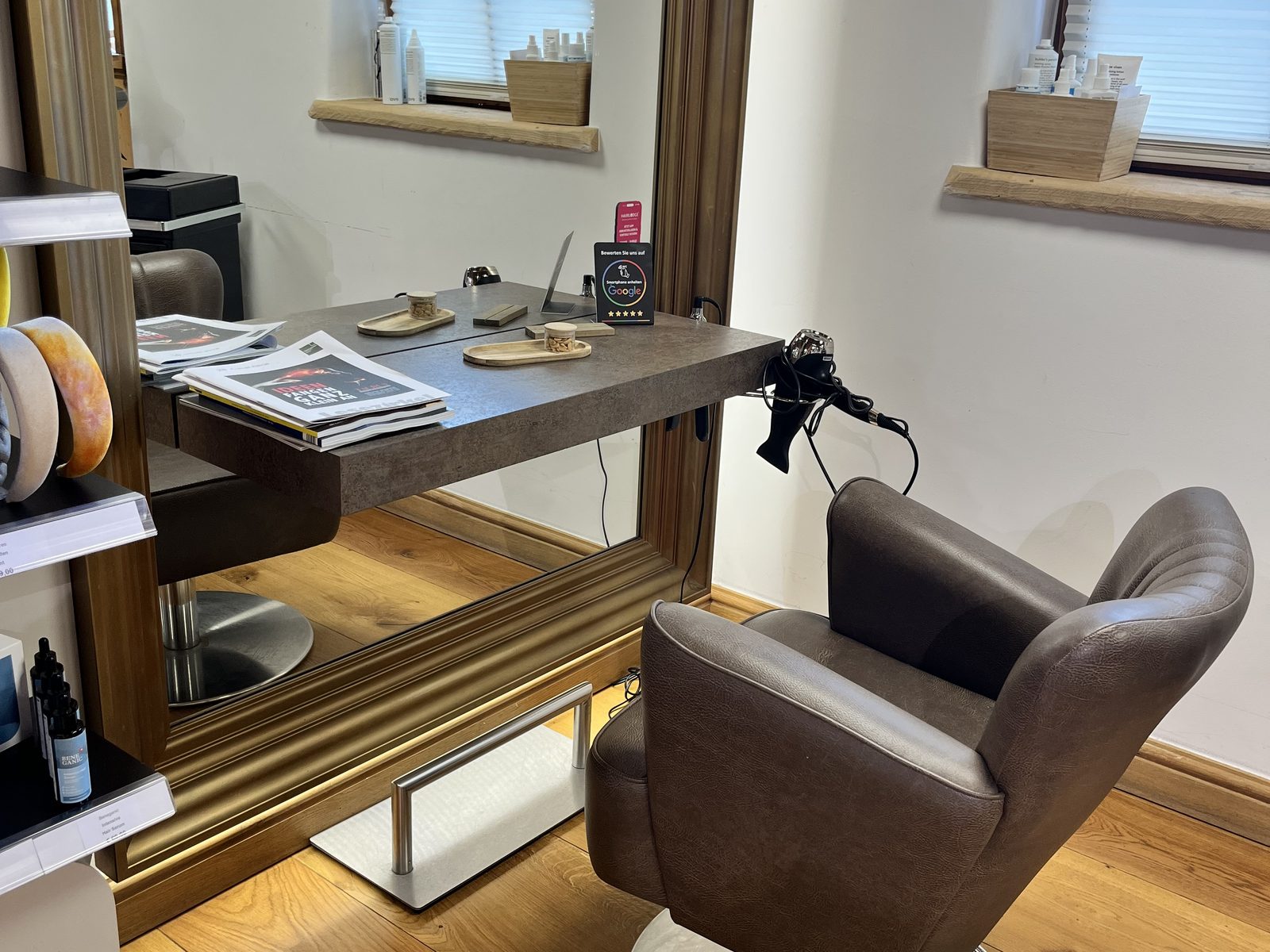 Styling station by the window at HAIRLODGE Stanglwirt, with mirror, console and daylight from the mullioned window.