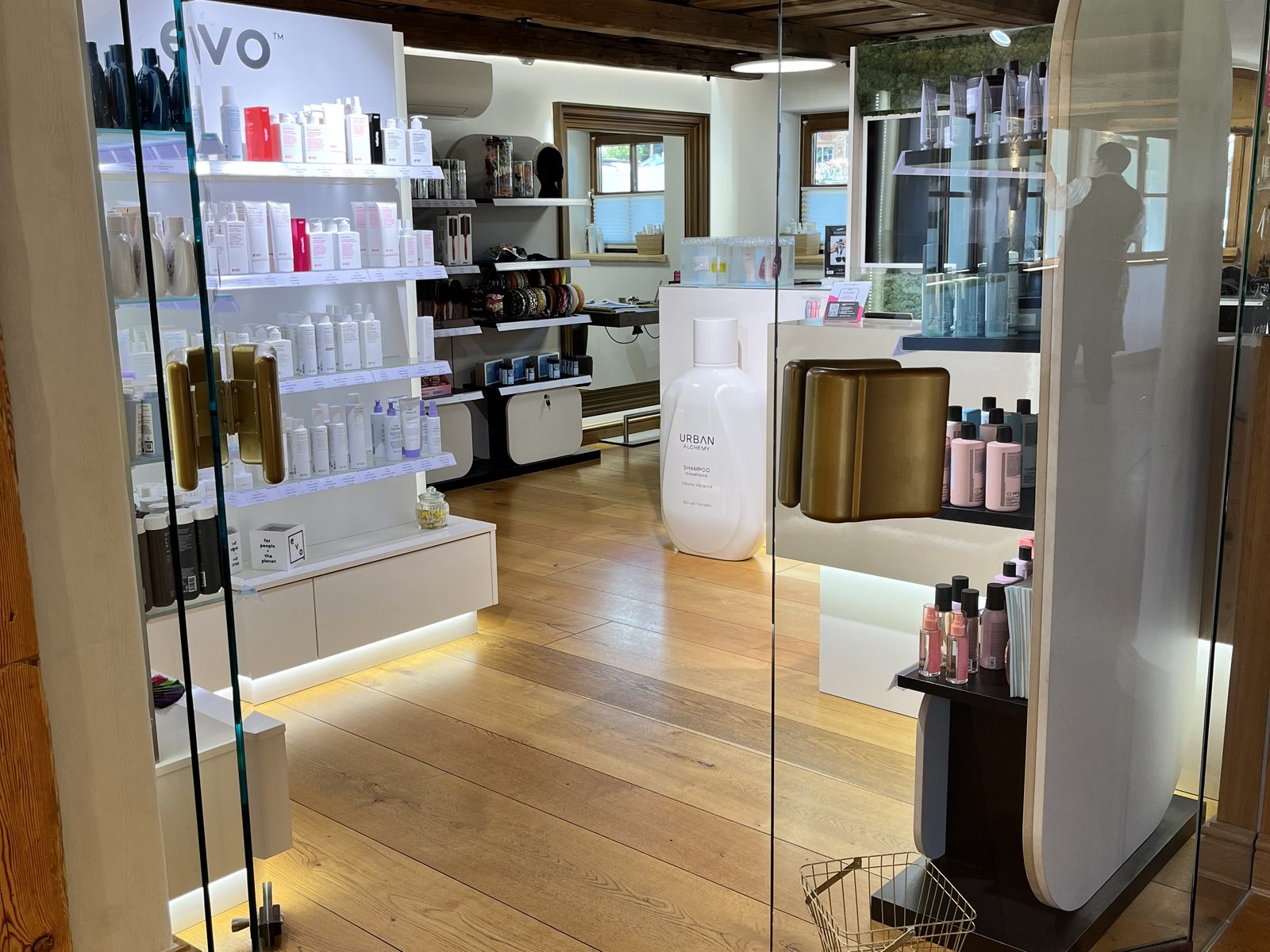 Retail area at HAIRLODGE Stanglwirt with the illuminated evo shelf wall, Urban Alchemy display and brush range.